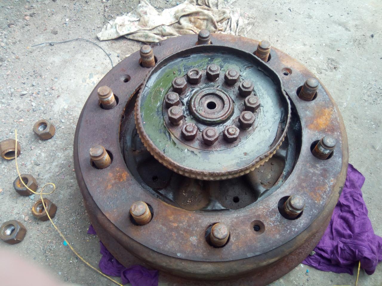 A brake drum and wheel hub laying on rags in a dusty yard. The
drum has just about separated from the wheel hub.