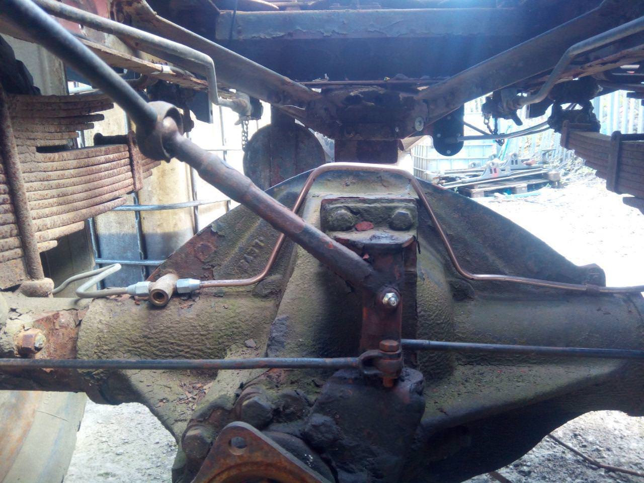 The back axle, photographed from in front, with a brand new copper brake line from the original fitting, up and over the diff, and</p>
<a class=
