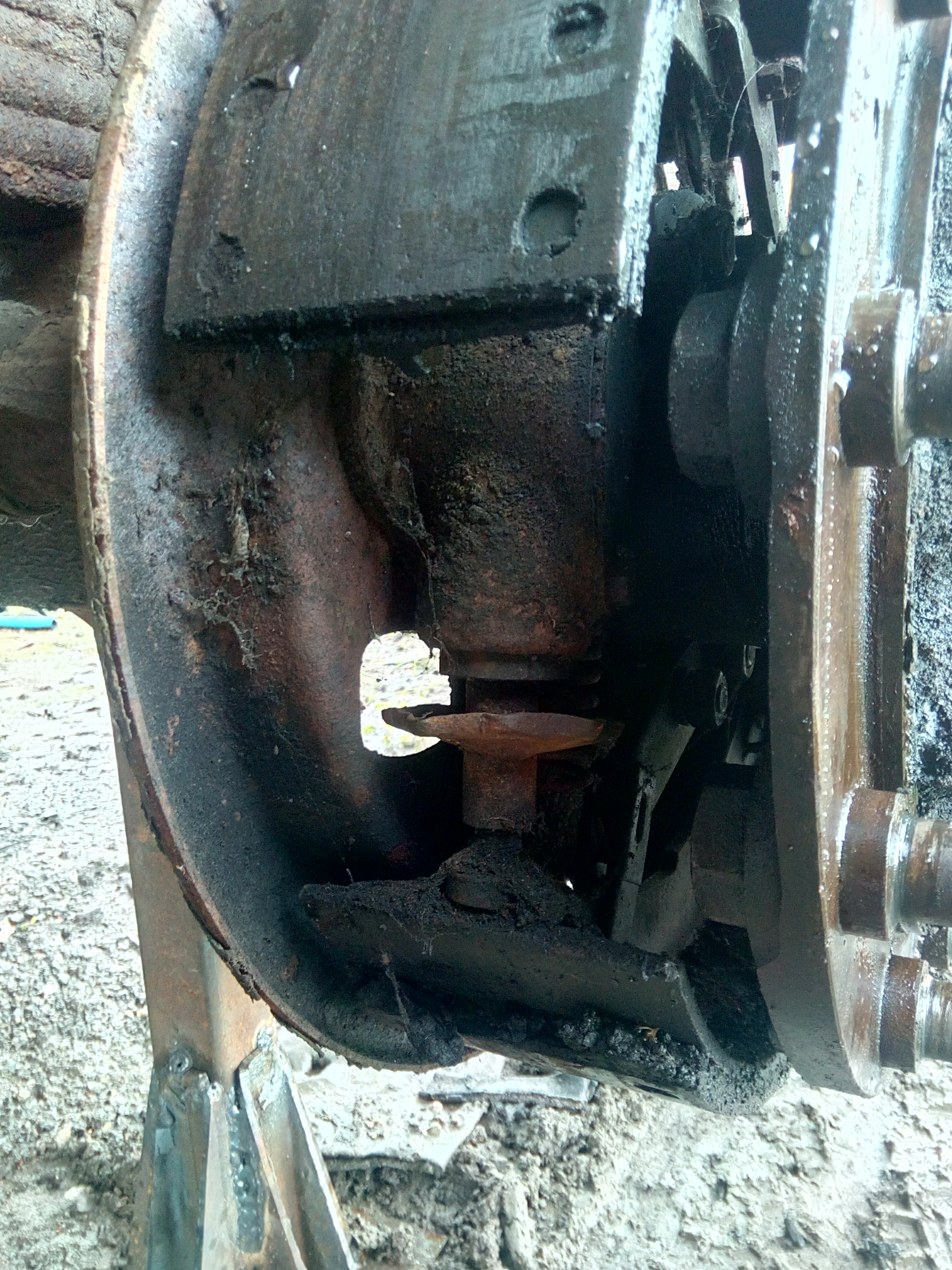 A close-up photograph of the brake mechanism, showing a large
buildup of grease, dirt, brake-dust, and cobwebs.