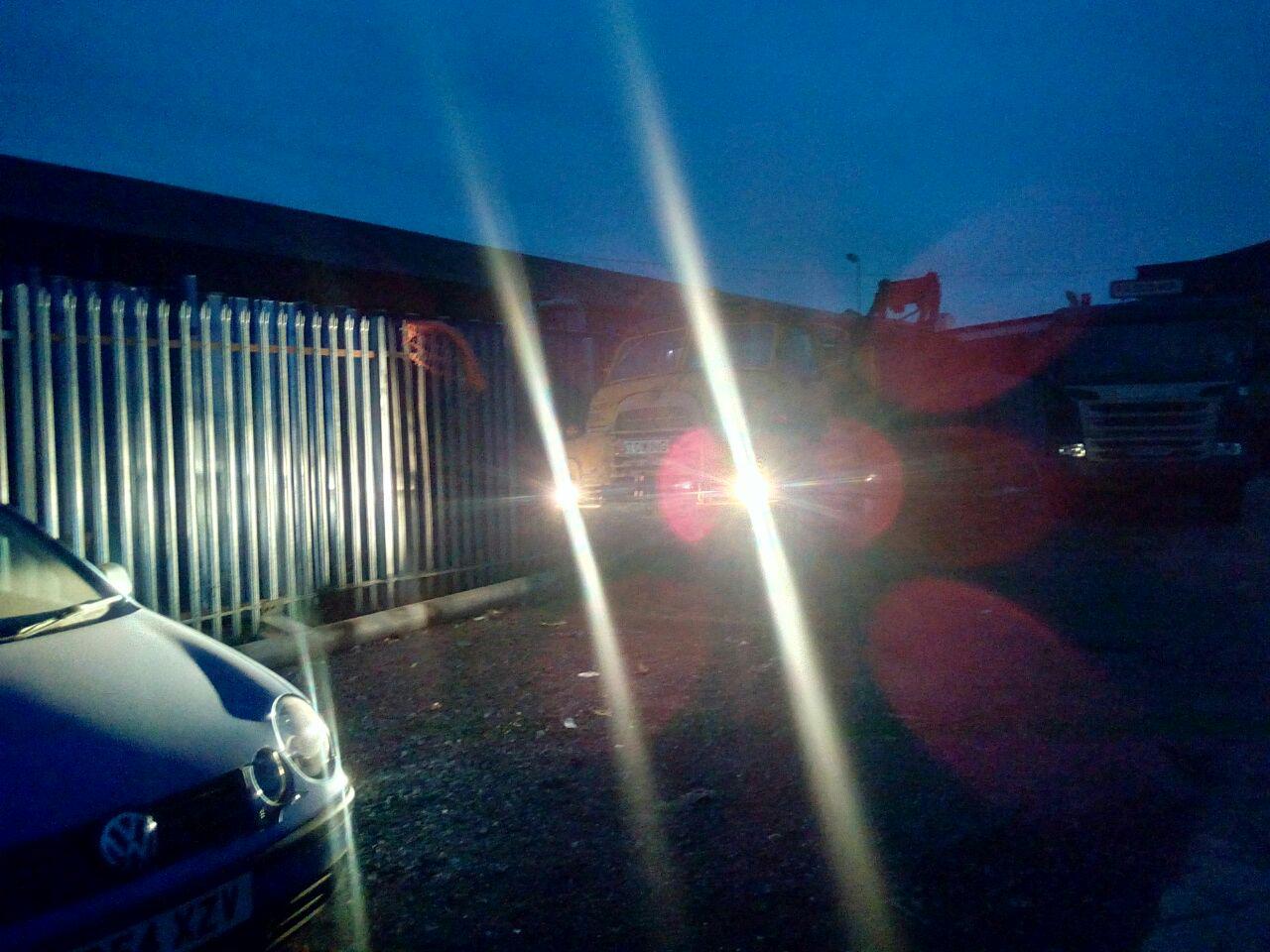 A poor-quality photograph of the truck parked in a dark storage
yard, with the headlights on. The light from the headlights is
smearing all over the photograph.