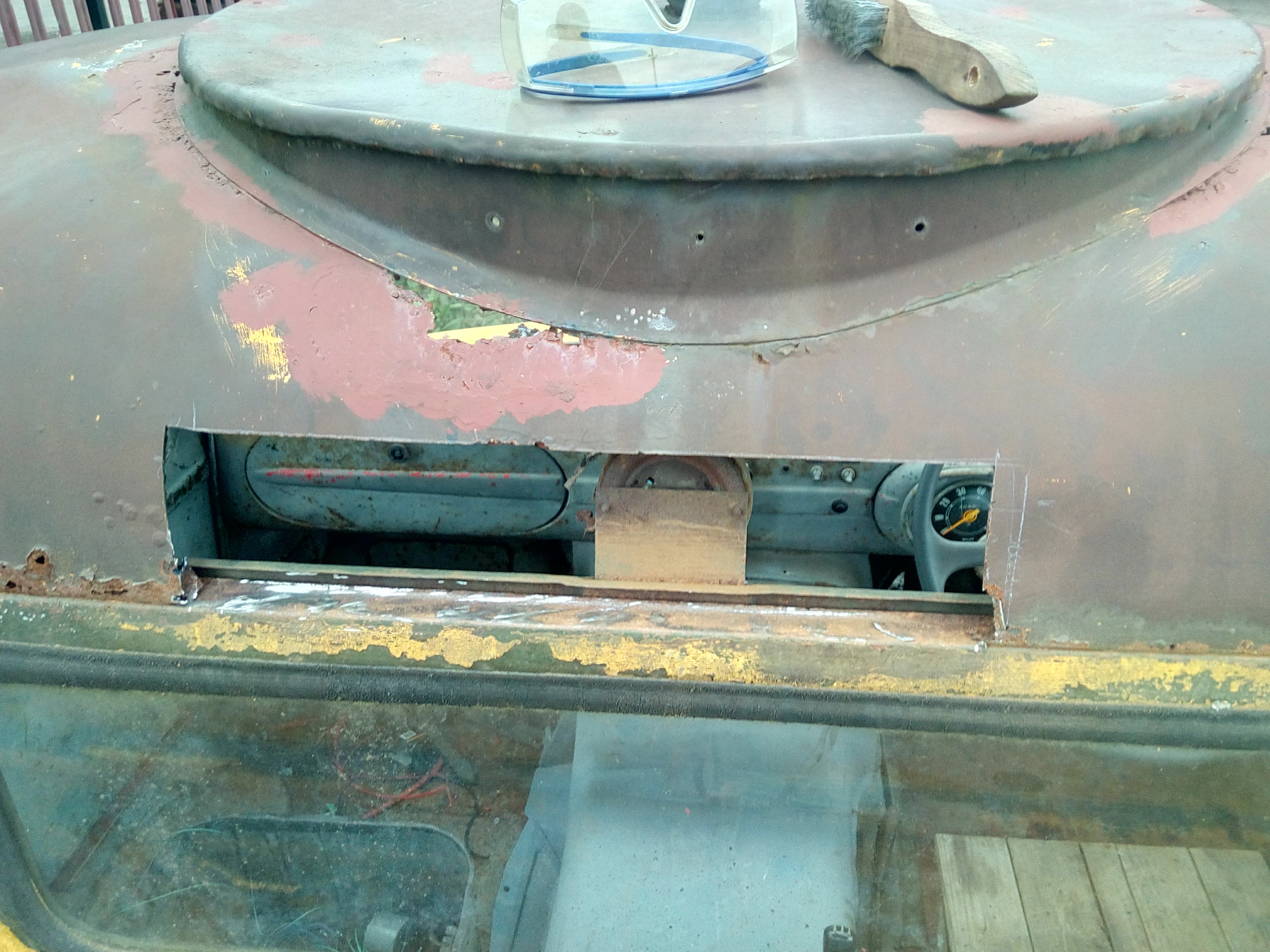 The back of the cab roof, now with a large section of rotten
metal cut out, leaving an even bigger -- but significantly neater --
hole through which the dashboard of the cab can be seen.