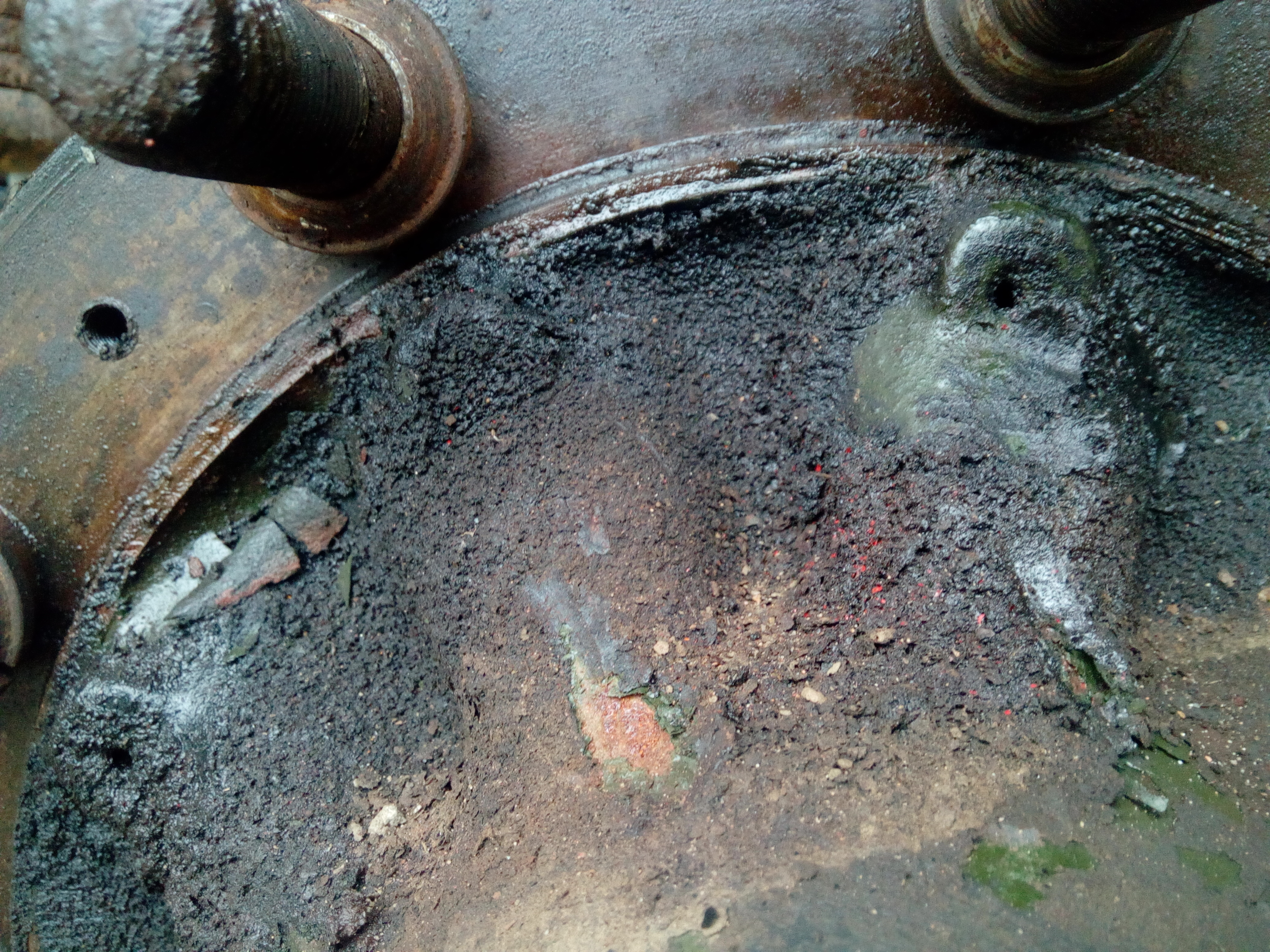 A close-up of an incredibly dirty rear wheel hub, soaked with
years of accumulated oil leakage and dirt that has built up to a heavy
slimy crust