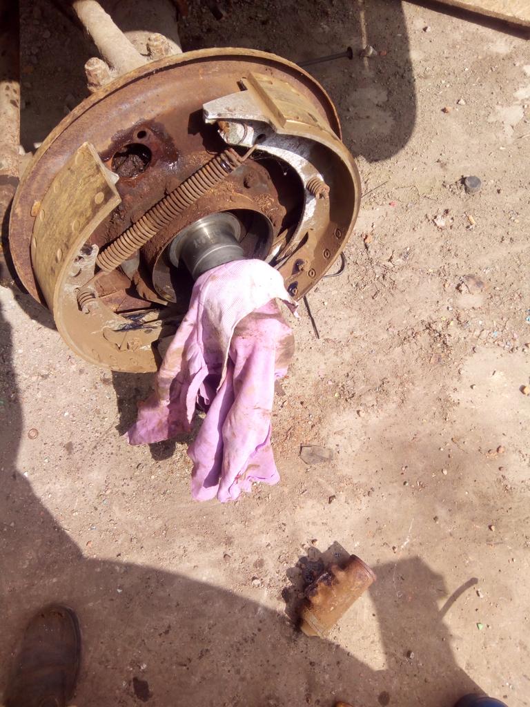 The front axle that the drum & hub was removed from, with the
stub axle covered up with a rag, and the very heavily corroded wheel
cylinder removed and thrown on the floor.