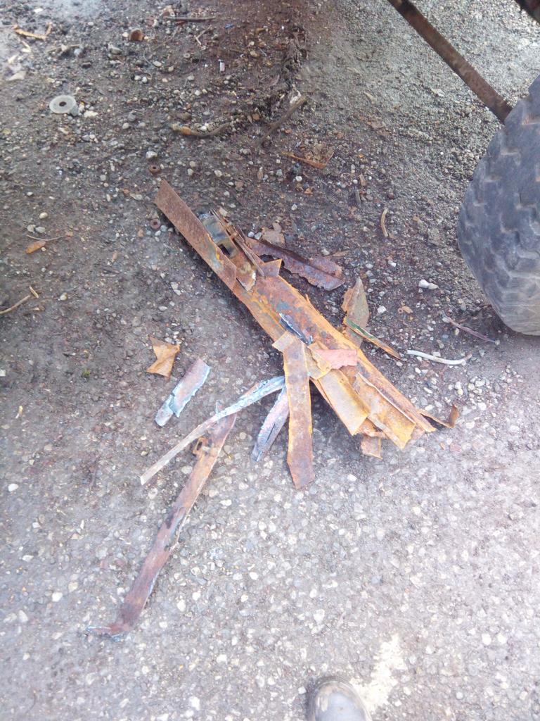 The mangled remains of the rear cab crossmember, in a heap on the
dirt floor.