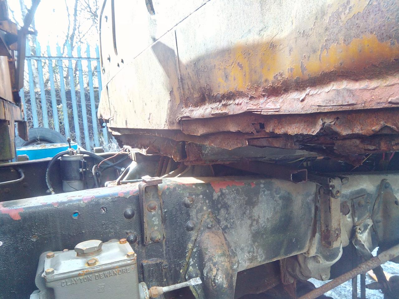 The back of the cab, showing multiple hacked off previous repairs
over rotten metal. It's a layer cake of rust and shit.