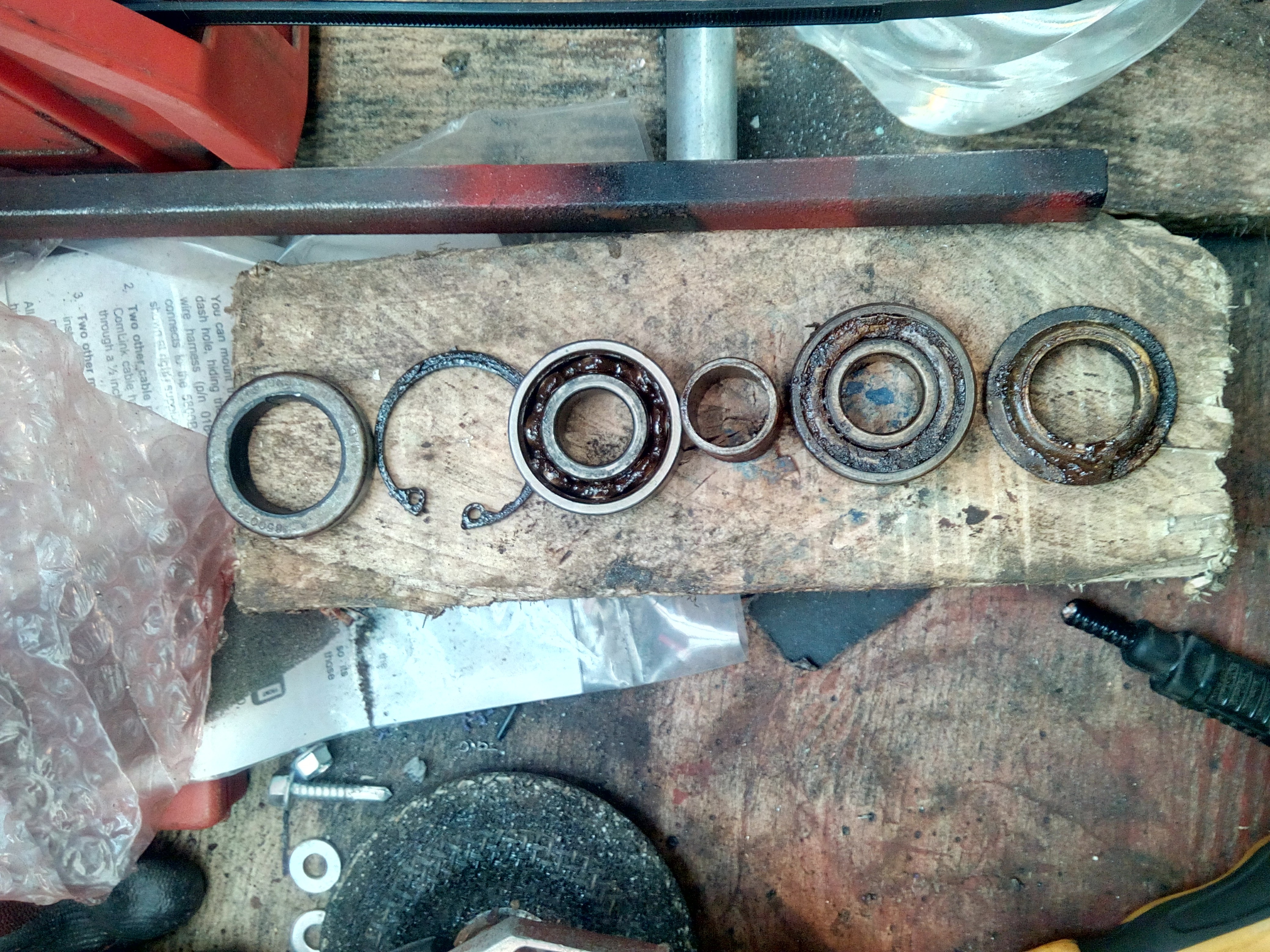 A line-up of the various water pump seals and bearings on the
bench. The seals are degraded, and the bearings are full of rust.