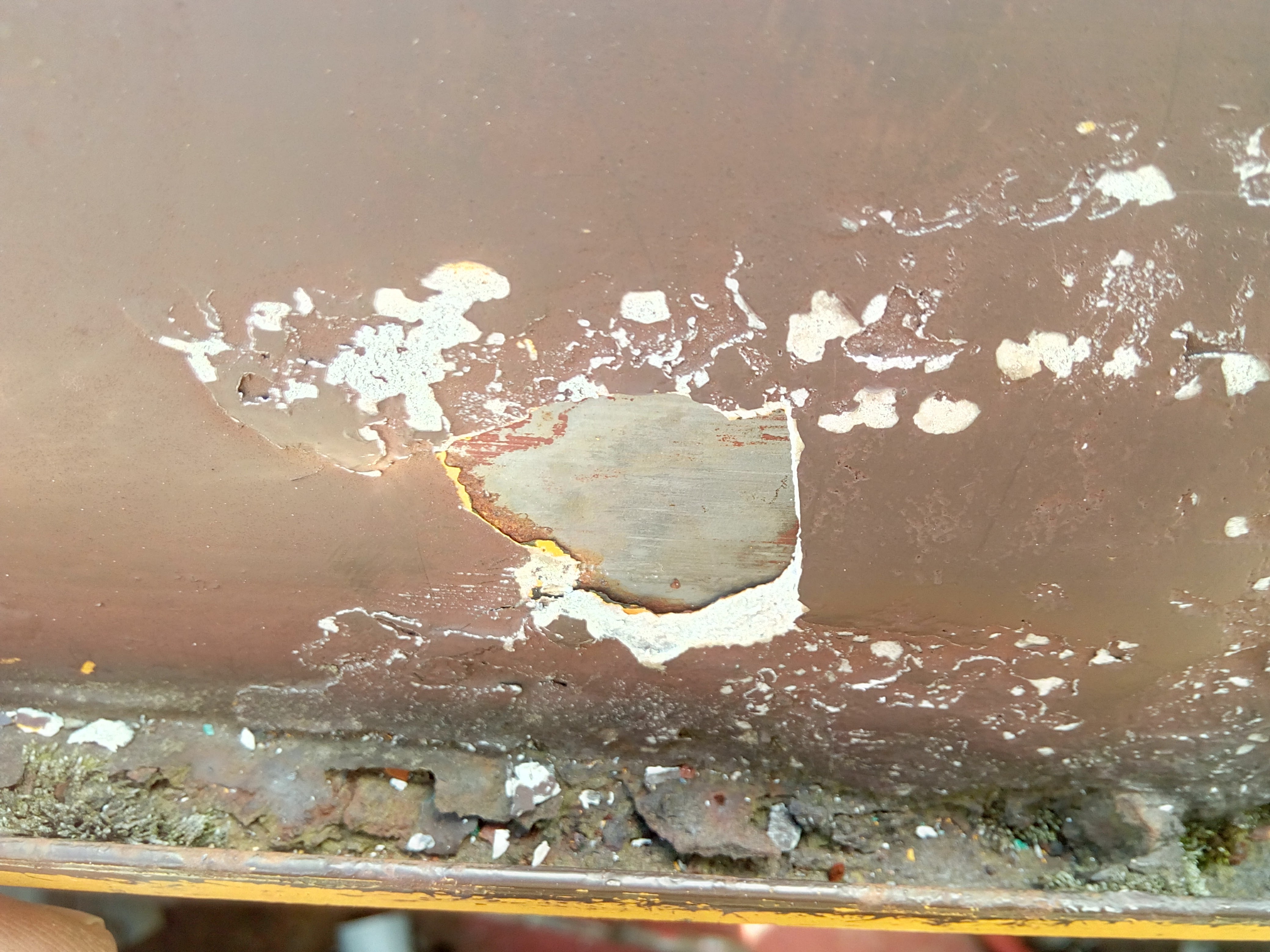 The previously photographed crust of filler has been pried off, revealing pristine sheet metal.