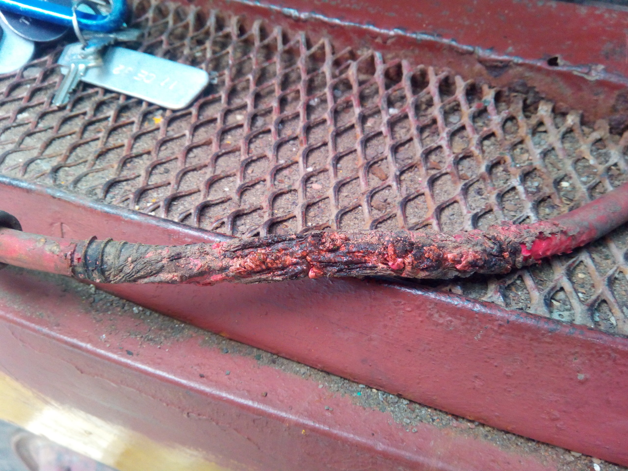 Very charred and burnt battery cable laying on the tread-plate of
the passenger's door step.