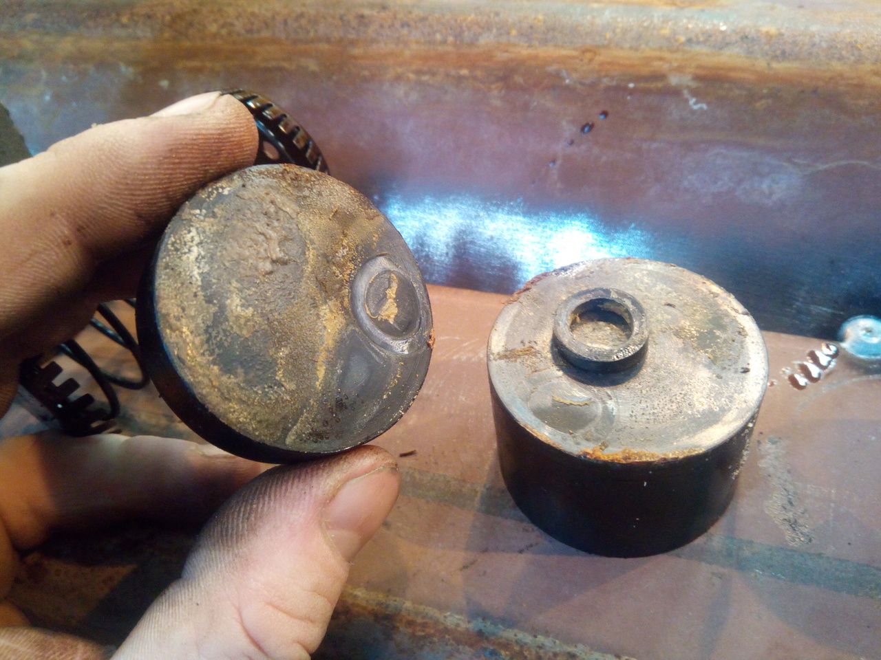 A hand lifting off the tilted cup-seal, revealing a square
section o-ring trapped beneath it