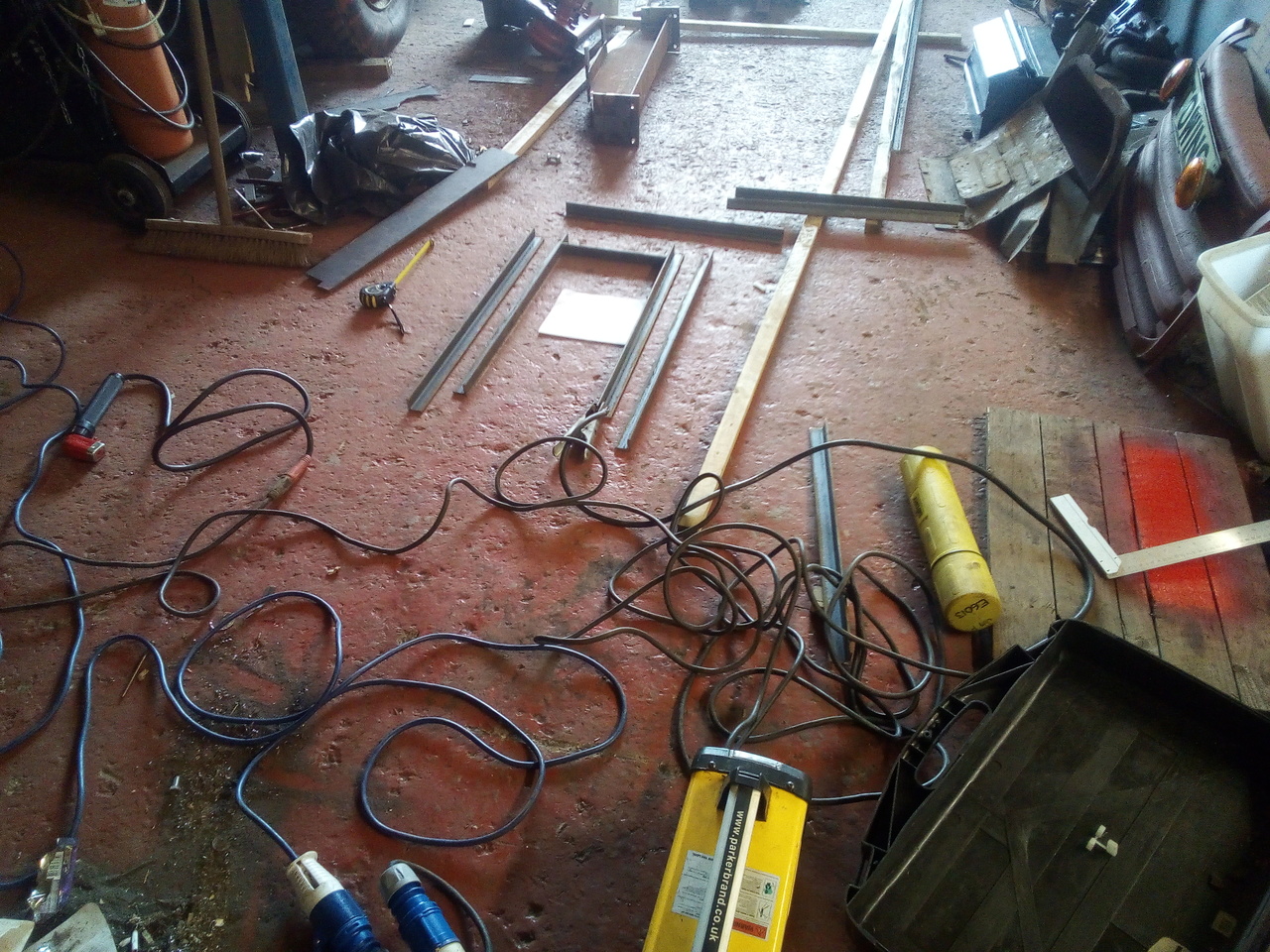 A framework taking shape in a very cluttered workshop, amid a
tangle of extension leads and welding cables.