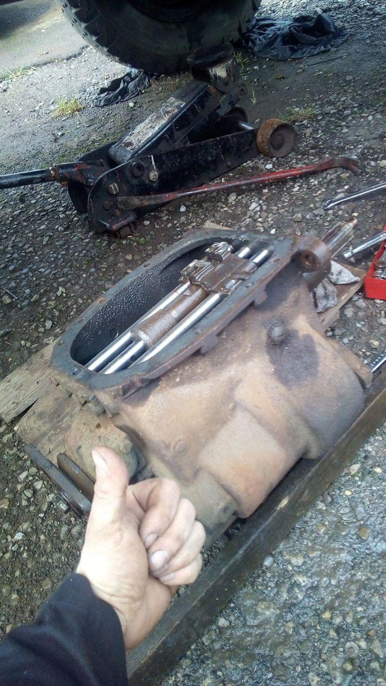 The gearbox, with its top removed, sitting on the floor in the
yard. A dirty hand gives a thumbs-up in front of it.