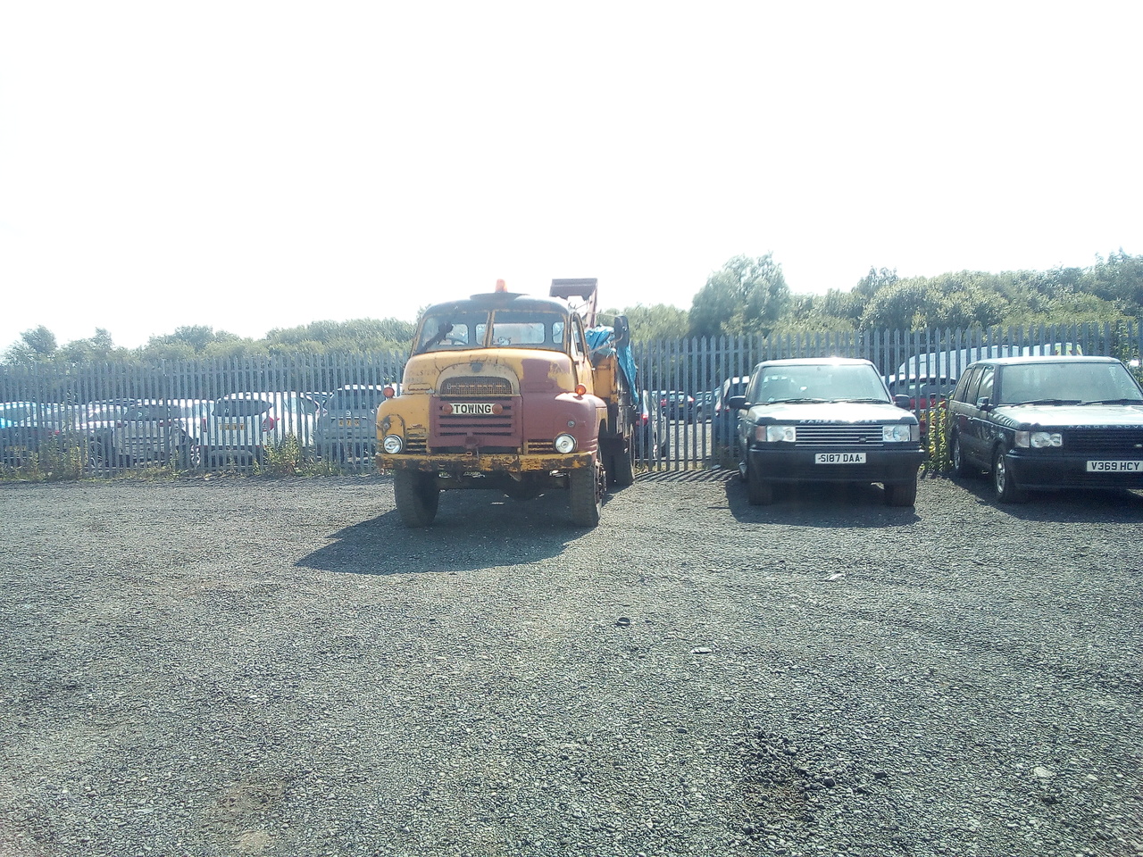 "Bedford parked up against a fence, sat alongside a pair of Range Rovers"
