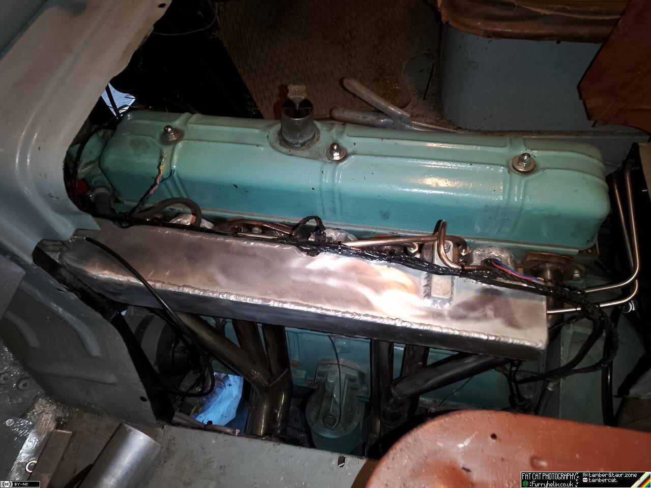 Big sheet metal aluminium intake fitted to the engine, in the truck, with its funky curvy fuel supply lines