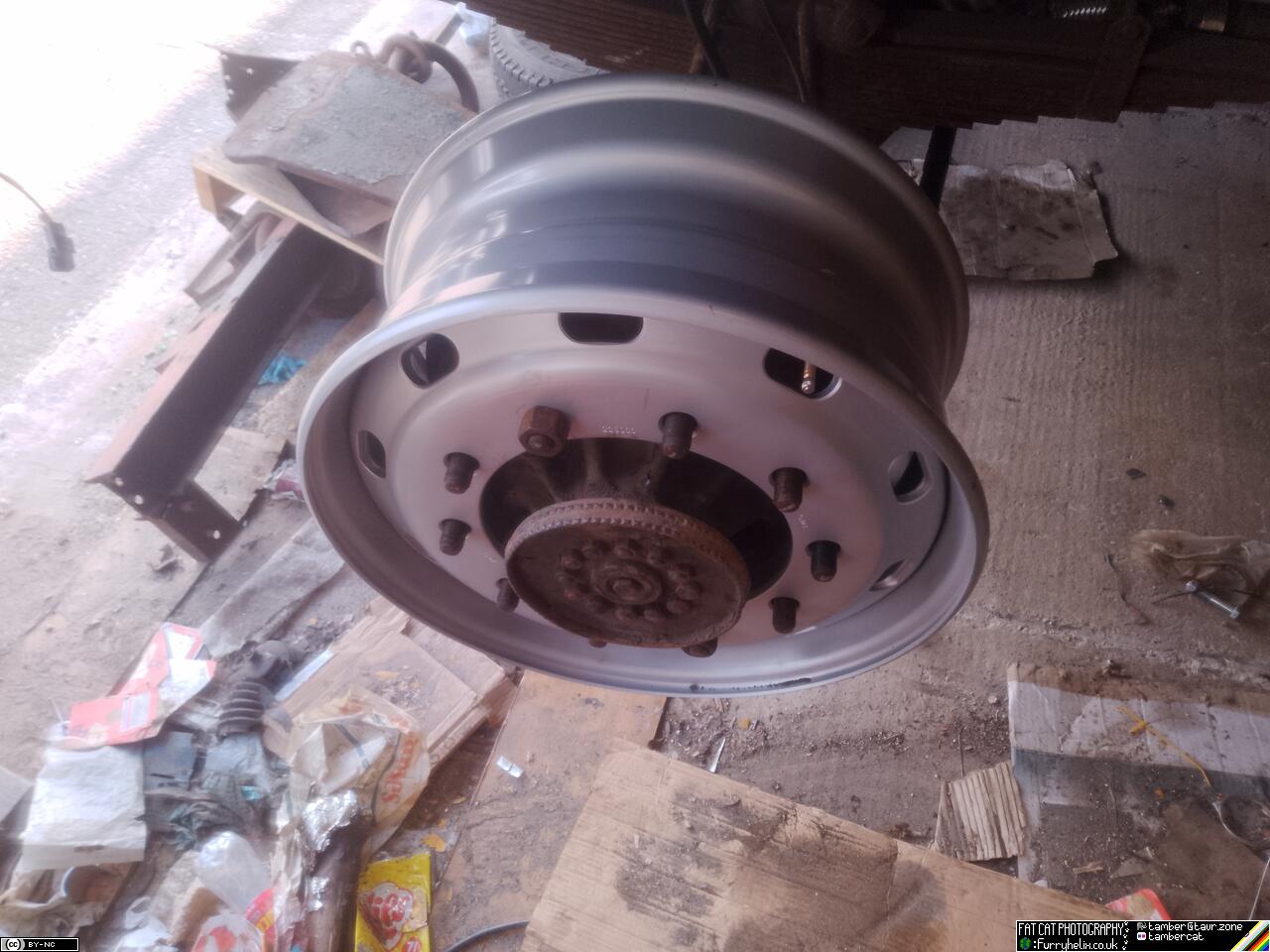 The shiny new wheel rim bolted up onto the truck
