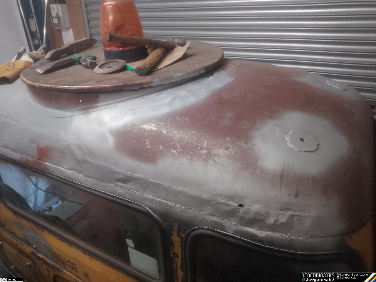 Back of the truck cab now all repaired and primer painted, with tools stacked on top of the roof