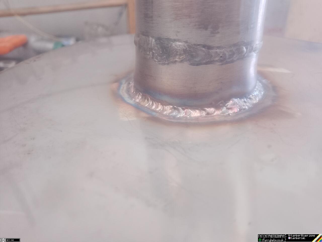 A piece of pipe welded into the centre of the big circle, with shiny but slightly lumpy welds
