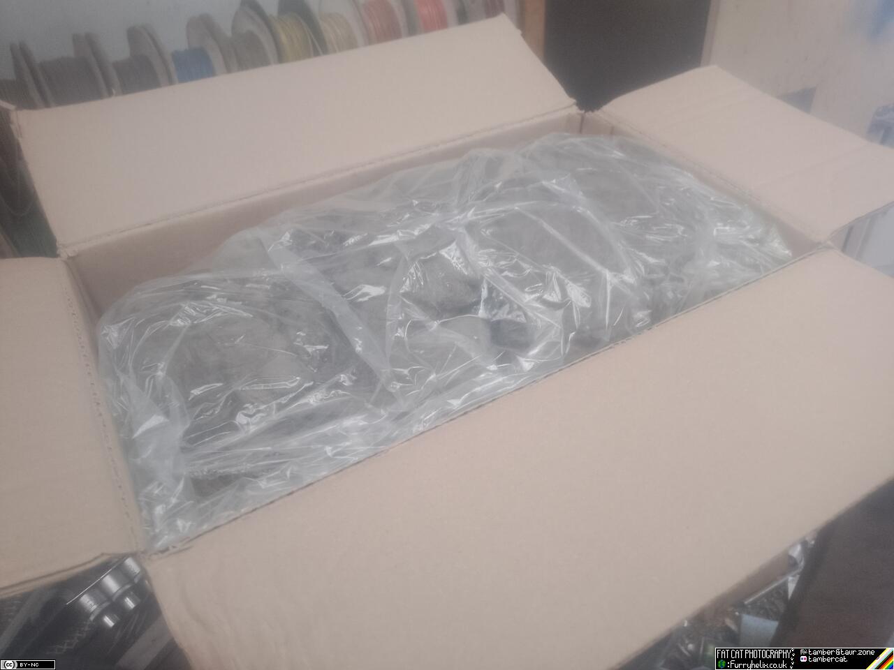 A big cardboard box, filled with plastic bags of brown rock-wool insulation sort of material