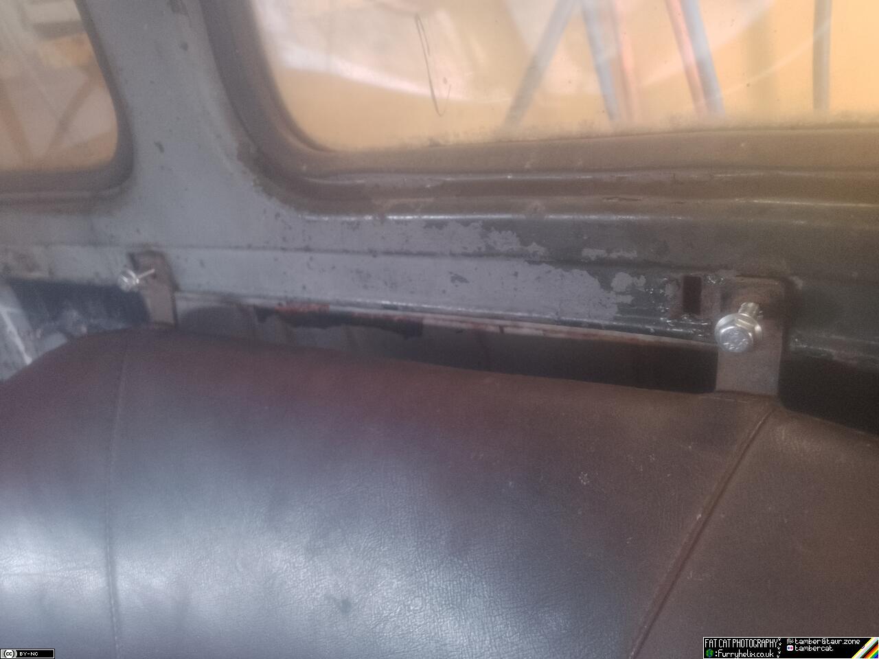 The seat-back installed in the cab with two excessively long, but shiny, bolts
