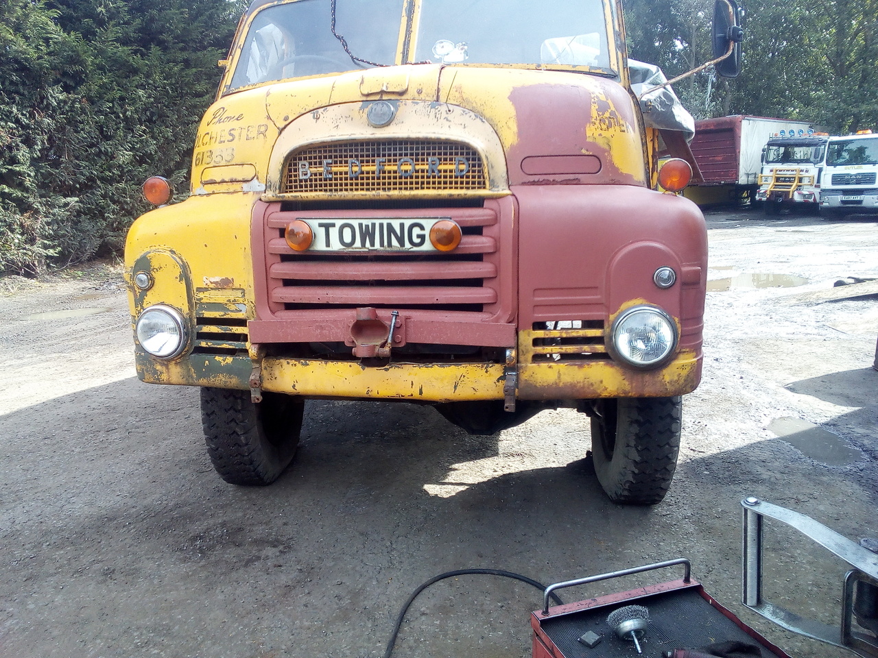 The bedford, parked in a dusty yard, with the front bumper
removed and a visible weld repair to the previously broken bumper
mount.