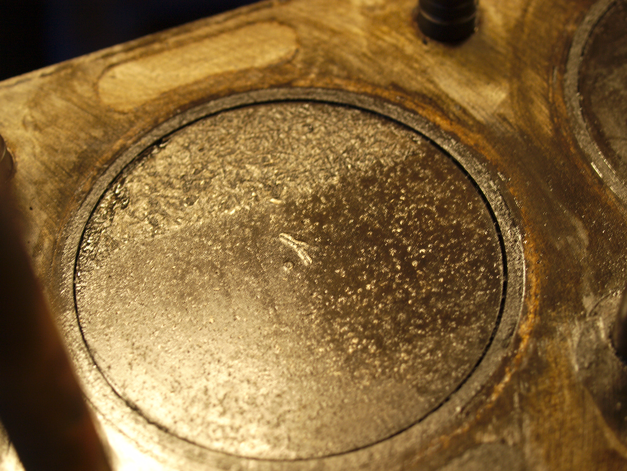 Close-up of the piston in number 4 cylinder, showing speckles of
damage in the top surface of the piston, as if it's been hitting some
small debris.