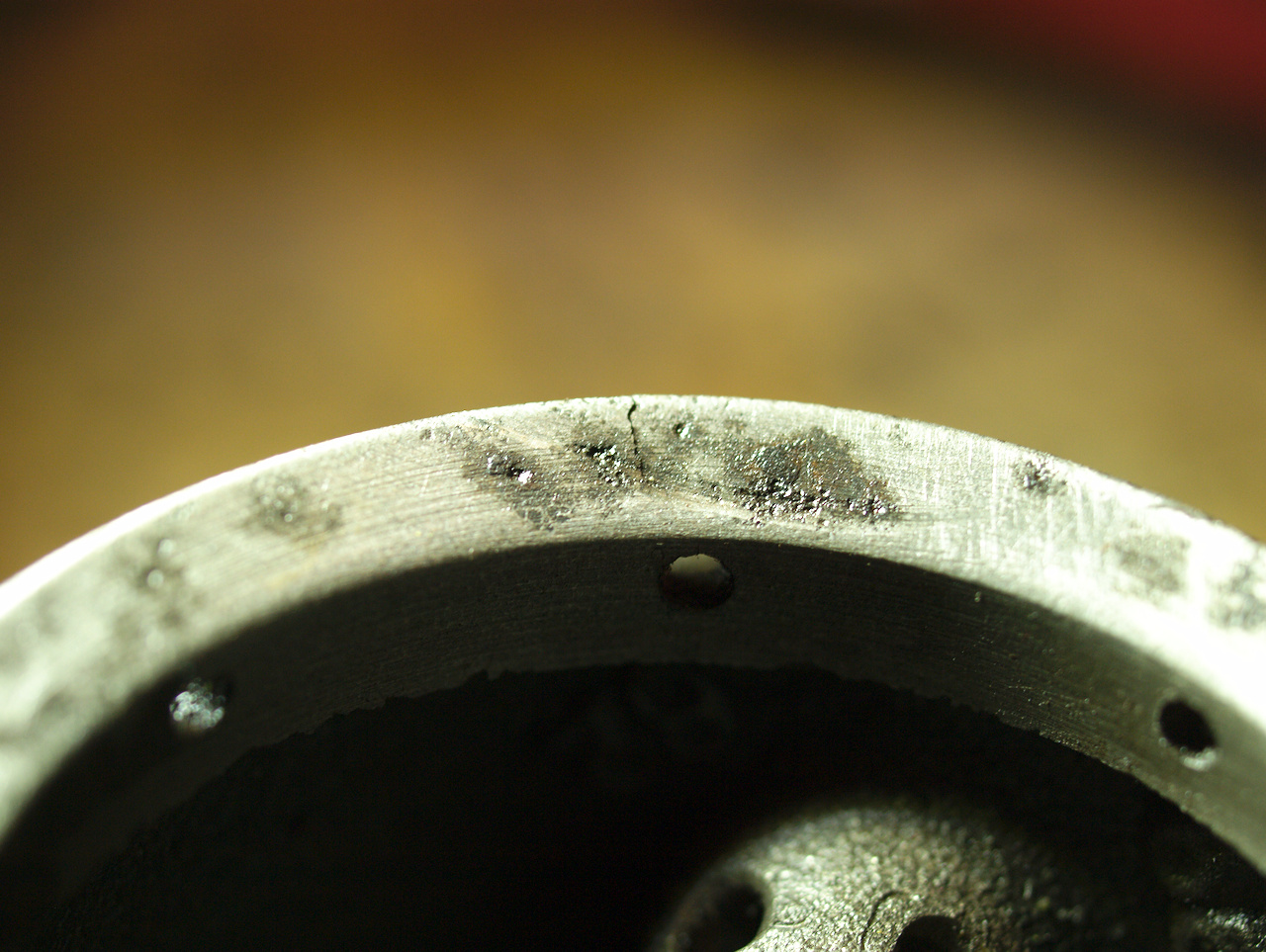 Close up of the underside of the piston's skirt, showing a
semicircular impact mark and a hairline crack in the cast iron
piston.