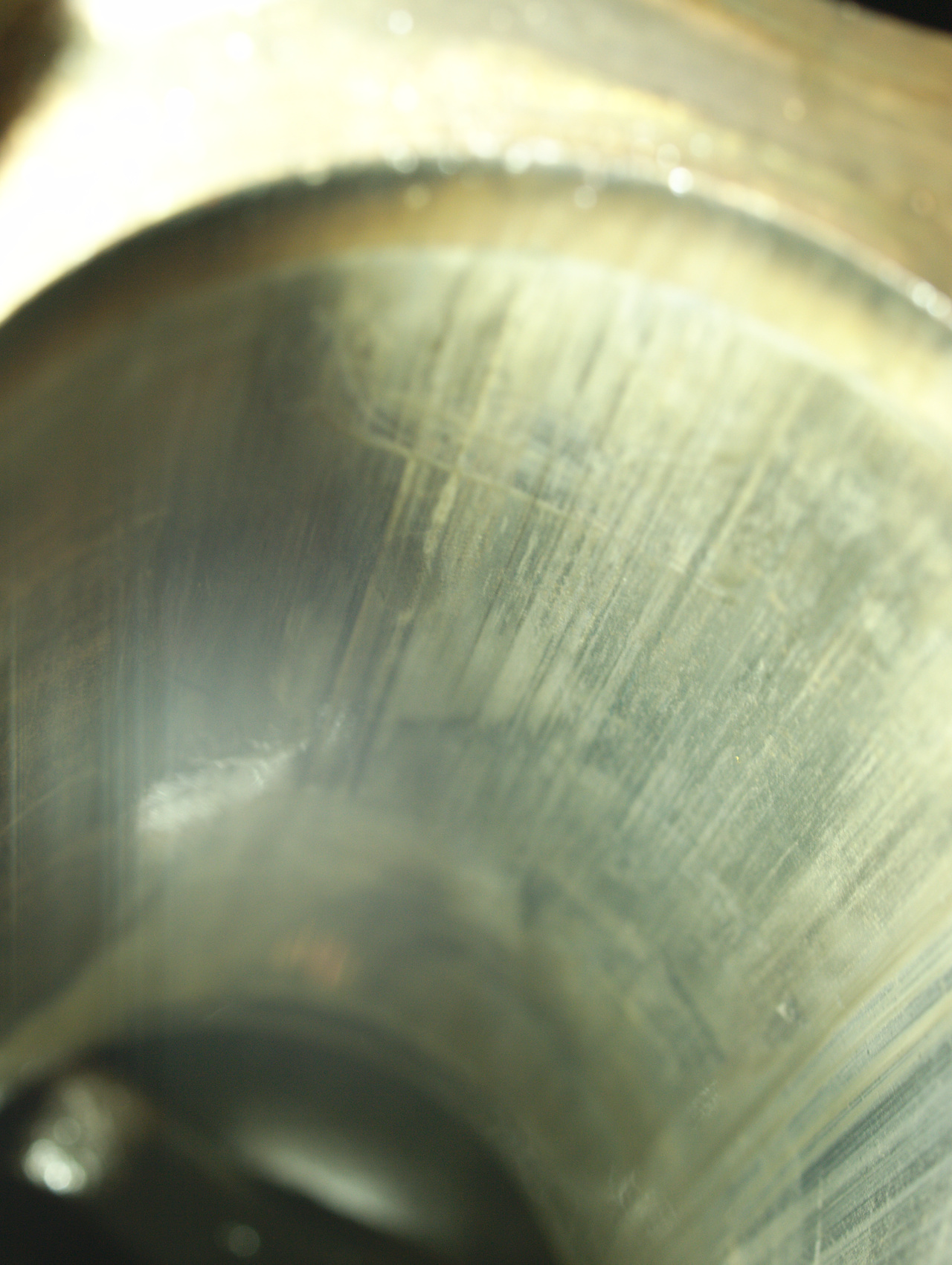A photograph down into a cylinder bore, showing an array of long
vertical scratches and discolouration.