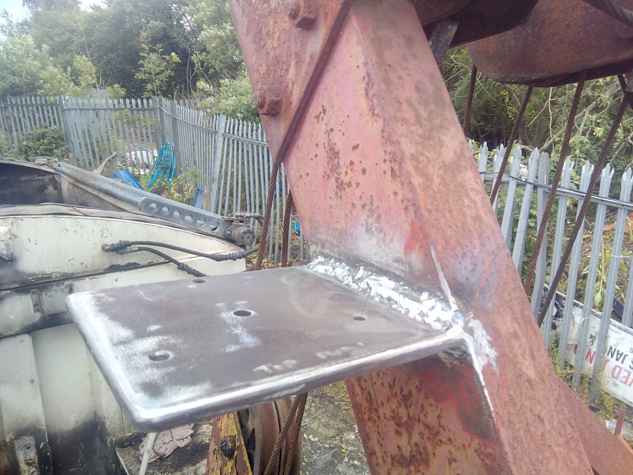 Close-up with a very thick and sturdy looking steel plate welded
to the side of the boom. The plate has 4 holes drilled into it, 3 in a
triangle, with the 4th in the centre.