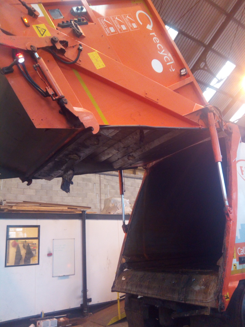 Rear hopper of refuse vehicle raised into the air, for emptying contents of the truck