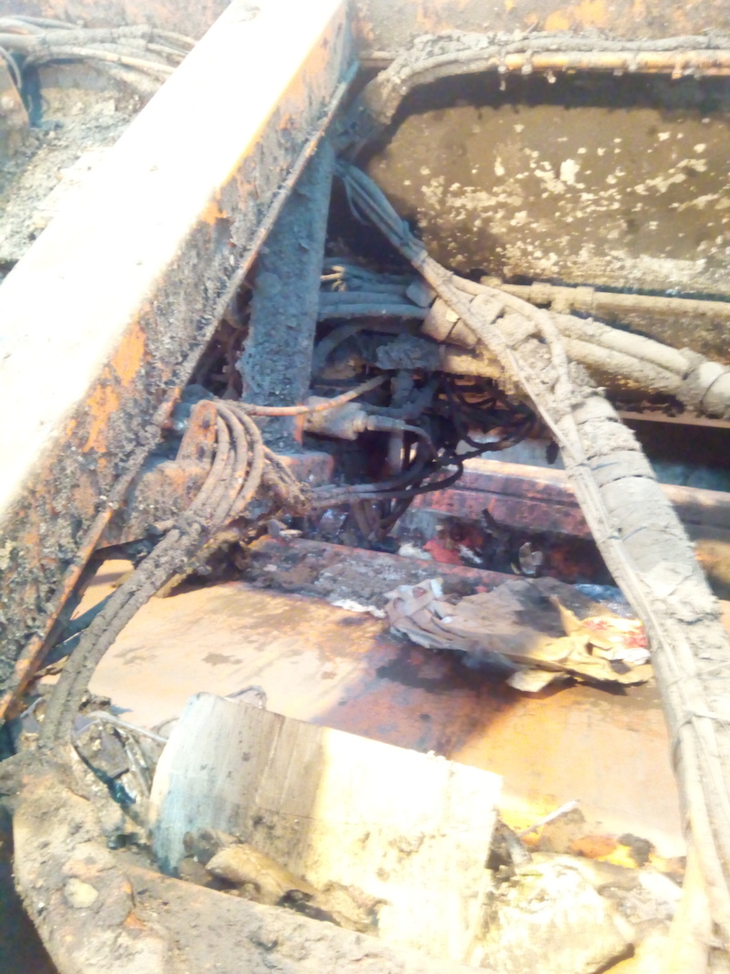 Valve block buried in pipes and wires, in the middle of the structure of the rear of the truck.